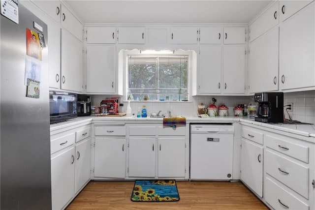 kitchen featuring white cabinets, stainless steel fridge, dishwasher, tile counters, and tasteful backsplash