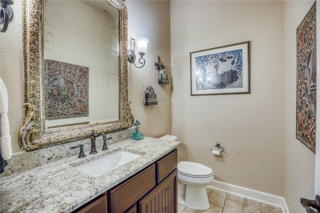 bathroom with toilet, baseboards, and vanity