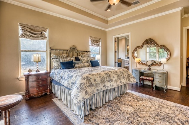 bedroom featuring ornamental molding, a tray ceiling, dark wood finished floors, and baseboards
