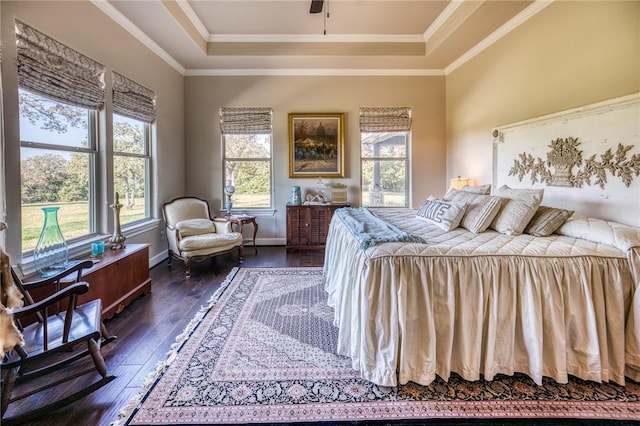 bedroom with dark wood-style floors, ornamental molding, a raised ceiling, and baseboards
