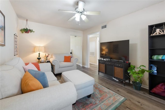 living room with baseboards, ceiling fan, visible vents, and wood finished floors