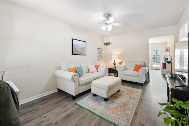 living room with a ceiling fan, french doors, baseboards, and wood finished floors