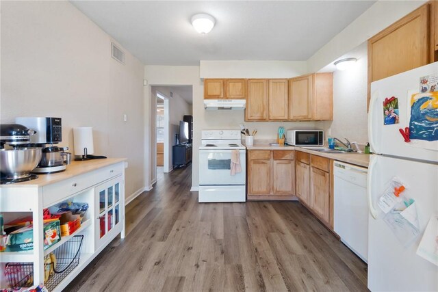 kitchen with white appliances, visible vents, light wood-style flooring, under cabinet range hood, and light brown cabinets