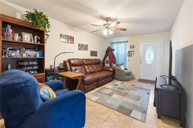 living area with light tile patterned floors and a ceiling fan