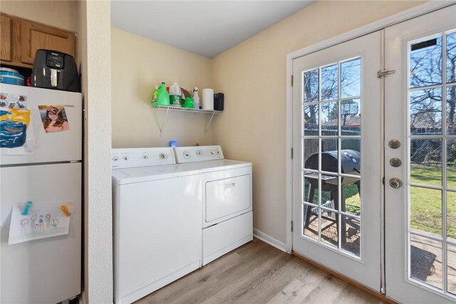 laundry area with laundry area, light wood-style flooring, washer and clothes dryer, and french doors