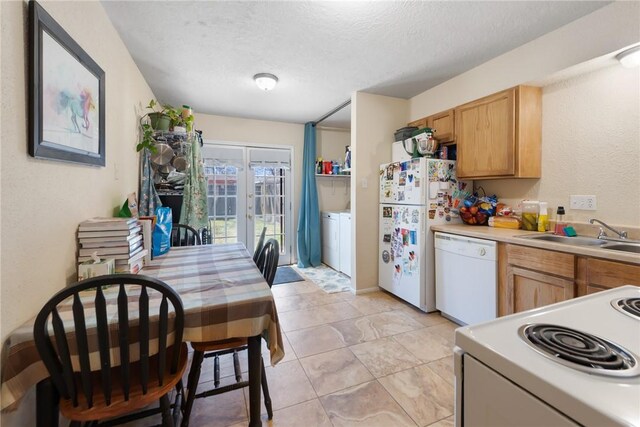 kitchen with washer / clothes dryer, light countertops, a sink, a textured ceiling, and white appliances