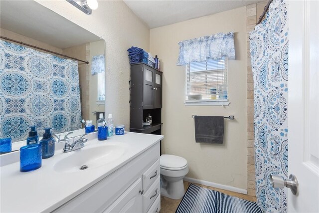 bathroom with a shower with curtain, baseboards, vanity, and toilet