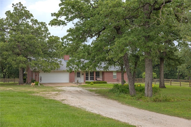 4988 Paso Fino Ln, Madisonville, TX 77864 - view of front of property featuring dirt driveway, an attached garage, brick siding, and a chimney
