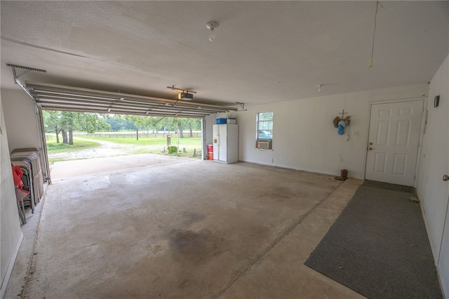4988 Paso Fino Ln, Madisonville, TX 77864 - garage with a garage door opener and cooling unit