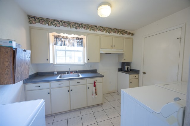 4988 Paso Fino Ln, Madisonville, TX 77864 - kitchen with under cabinet range hood, a sink, washer and dryer, and light tile patterned floors