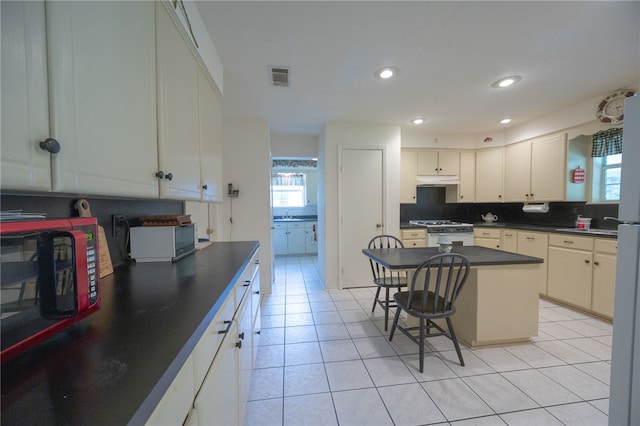 4988 Paso Fino Ln, Madisonville, TX 77864 - kitchen with dark countertops, plenty of natural light, a breakfast bar area, white cabinetry, and recessed lighting