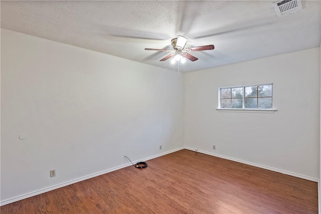 spare room with a textured ceiling, wood-type flooring, and ceiling fan