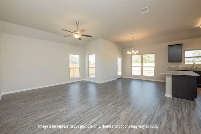 unfurnished living room featuring ceiling fan with notable chandelier, dark wood-type flooring, a healthy amount of sunlight, and sink