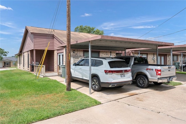 view of front of home with brick siding, a front lawn, and an attached carport