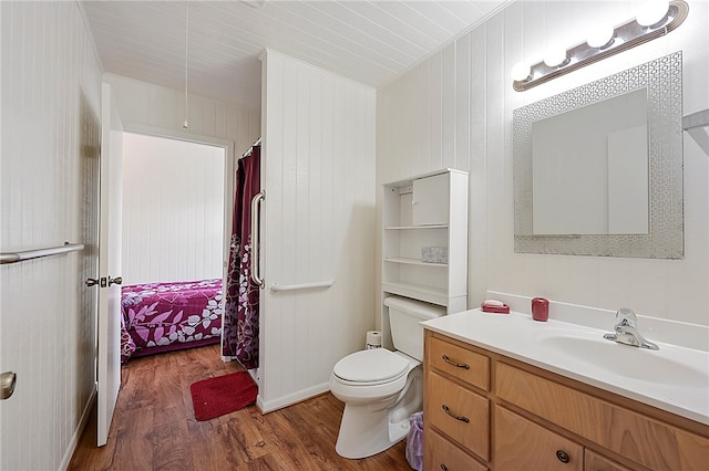 full bathroom featuring toilet, wood finished floors, and vanity