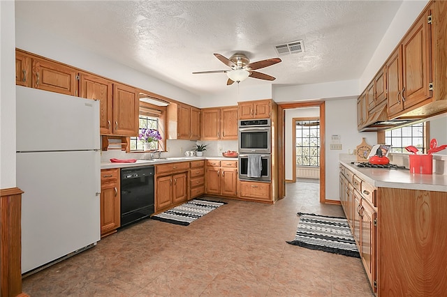 kitchen with visible vents, dishwasher, freestanding refrigerator, light countertops, and stainless steel double oven