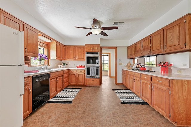 kitchen with light countertops, visible vents, appliances with stainless steel finishes, a sink, and ceiling fan