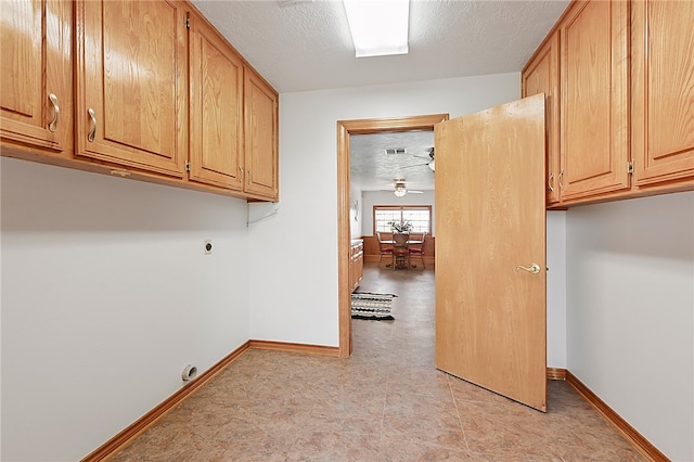 laundry area featuring cabinet space, a textured ceiling, baseboards, and hookup for an electric dryer