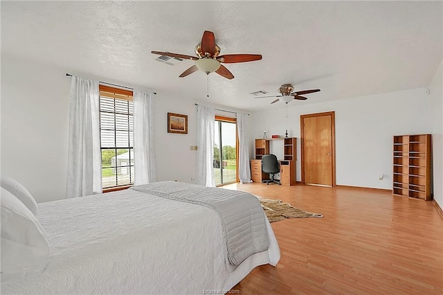 bedroom with visible vents, light wood-style flooring, ceiling fan, a textured ceiling, and access to outside