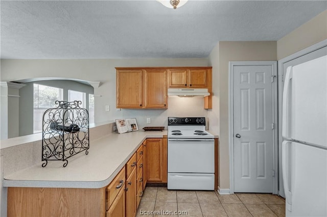 kitchen featuring light tile patterned floors, white appliances, and a textured ceiling