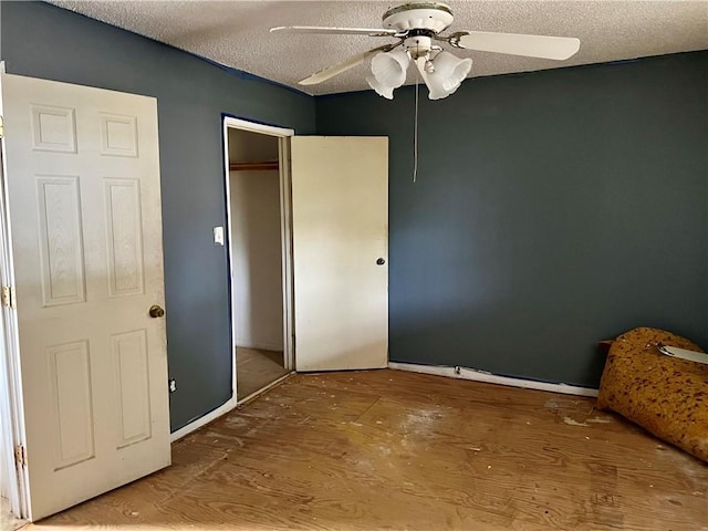 808 W Boundary St, Giddings, TX 78942 - unfurnished bedroom with hardwood / wood-style floors, a textured ceiling, a closet, and ceiling fan
