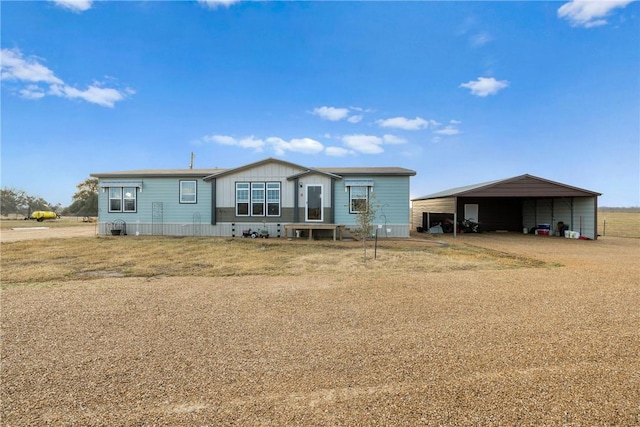 manufactured / mobile home with driveway, a front yard, and a detached carport