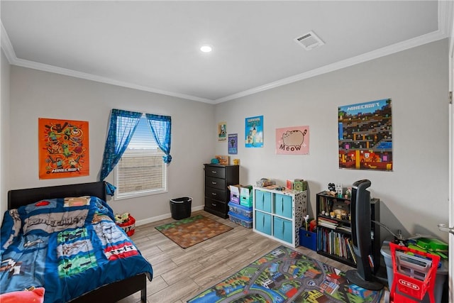 bedroom featuring light wood finished floors, baseboards, visible vents, and crown molding