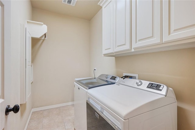 laundry room featuring cabinets, separate washer and dryer, and light tile patterned flooring