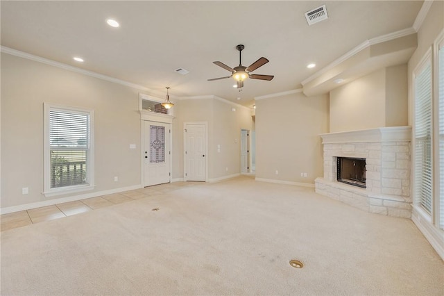 unfurnished living room with light colored carpet, a stone fireplace, ceiling fan, and ornamental molding