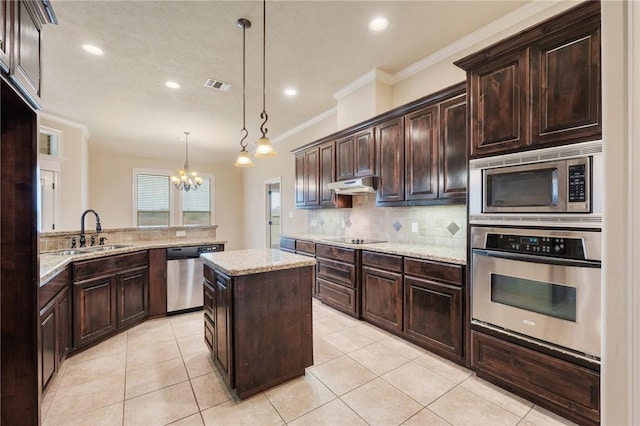 kitchen featuring kitchen peninsula, appliances with stainless steel finishes, sink, decorative light fixtures, and a kitchen island