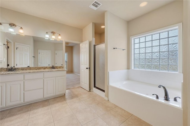 bathroom featuring tile patterned floors, vanity, and plus walk in shower