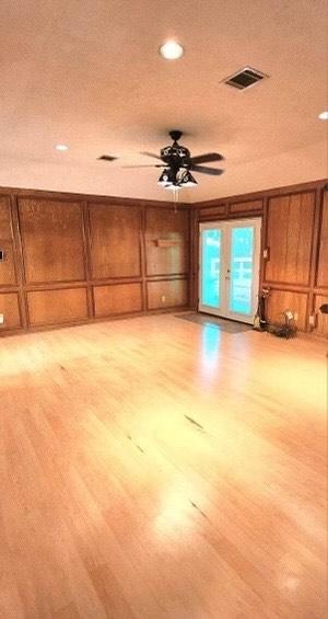 1706 Shawnee St, Navasota, TX 77868 - unfurnished living room featuring light wood finished floors, ceiling fan, recessed lighting, and a decorative wall