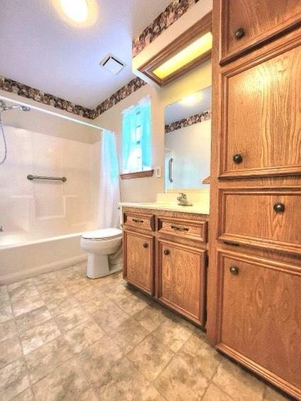 1706 Shawnee St, Navasota, TX 77868 - bathroom with shower / tub combo with curtain, toilet, and vanity