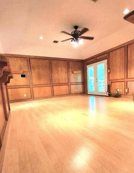 1706 Shawnee St, Navasota, TX 77868 - unfurnished living room with a decorative wall, french doors, ceiling fan, light wood finished floors, and recessed lighting