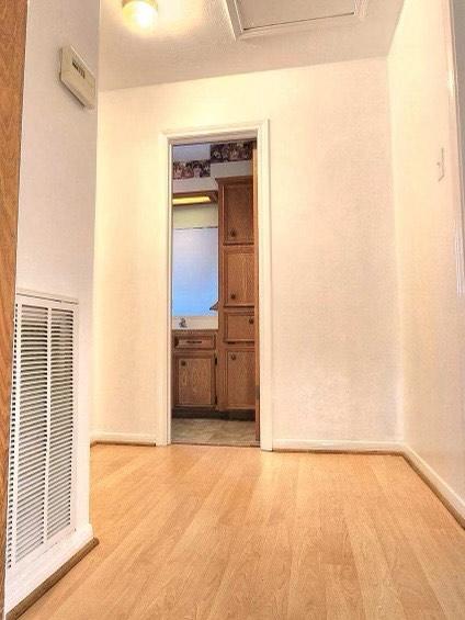 1706 Shawnee St, Navasota, TX 77868 - unfurnished room with wood finished floors, a heating unit, and baseboards