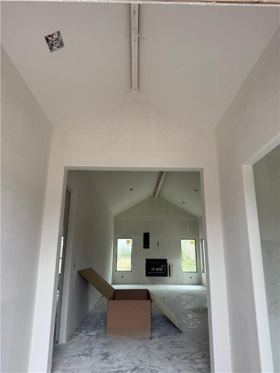 corridor with beamed ceiling and high vaulted ceiling