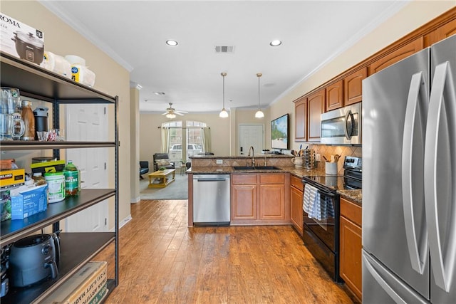 kitchen featuring a sink, ceiling fan, a peninsula, appliances with stainless steel finishes, and visible vents