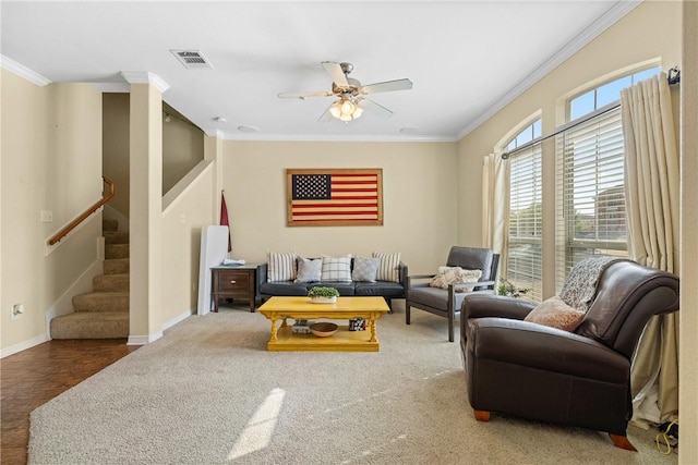 living area with stairway, visible vents, crown molding, and a ceiling fan
