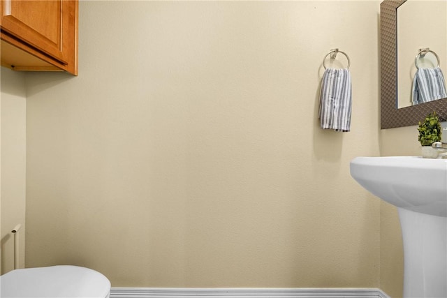 bathroom with toilet and baseboards