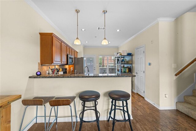 kitchen featuring a peninsula, dark wood finished floors, baseboards, visible vents, and appliances with stainless steel finishes