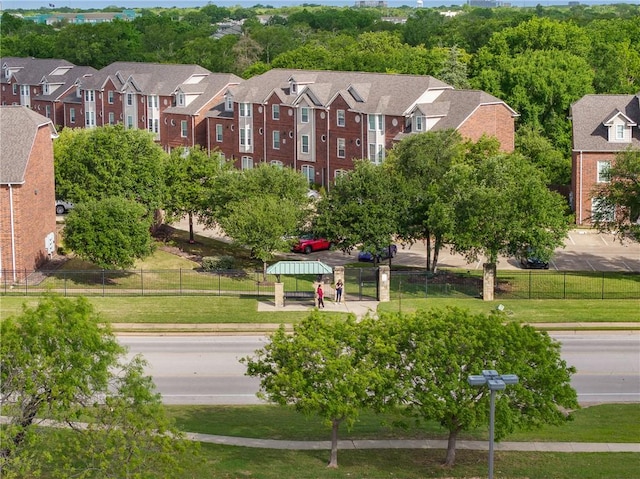 view of home's community featuring fence, a lawn, and a residential view