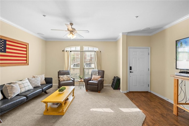 living room with wood finished floors, crown molding, baseboards, and a ceiling fan