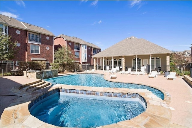 view of pool featuring an in ground hot tub, pool water feature, and a patio area