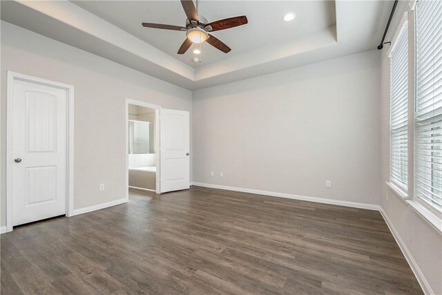 4706 Coyotillo Way, Bryan, TX 77807 - unfurnished bedroom featuring a raised ceiling, dark wood finished floors, ensuite bath, recessed lighting, and a ceiling fan