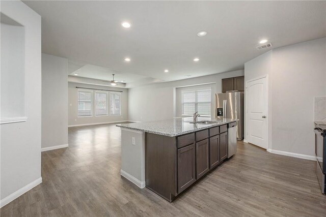 4706 Coyotillo Way, Bryan, TX 77807 - kitchen featuring wood finished floors, ceiling fan, a kitchen island with sink, healthy amount of natural light, and recessed lighting