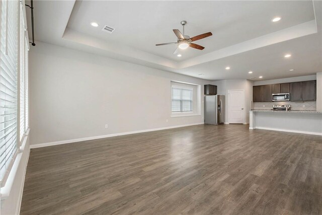 4706 Coyotillo Way, Bryan, TX 77807 - unfurnished living room featuring a raised ceiling, ceiling fan, dark wood-type flooring, and recessed lighting