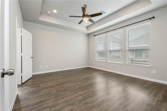 4706 Coyotillo Way, Bryan, TX 77807 - spare room featuring a tray ceiling, a ceiling fan, dark wood-style floors, and recessed lighting