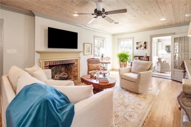 living area featuring ceiling fan, wood ceiling, ornamental molding, a fireplace, and wood finished floors