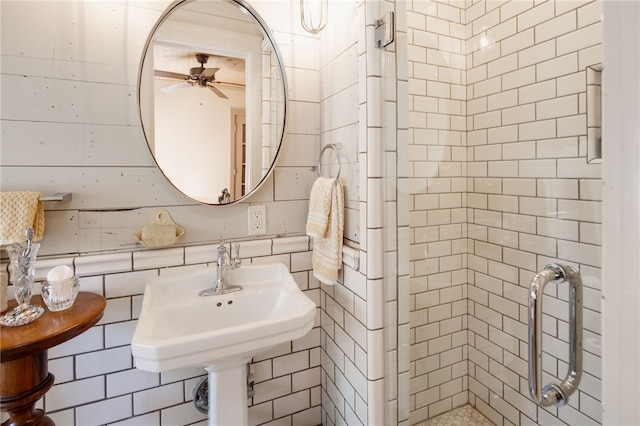 bathroom featuring a sink, tile walls, a stall shower, and a ceiling fan