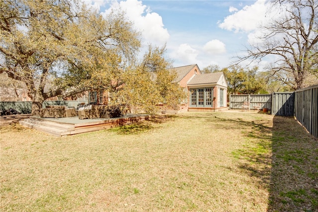 view of yard featuring french doors, a fenced backyard, and a wooden deck